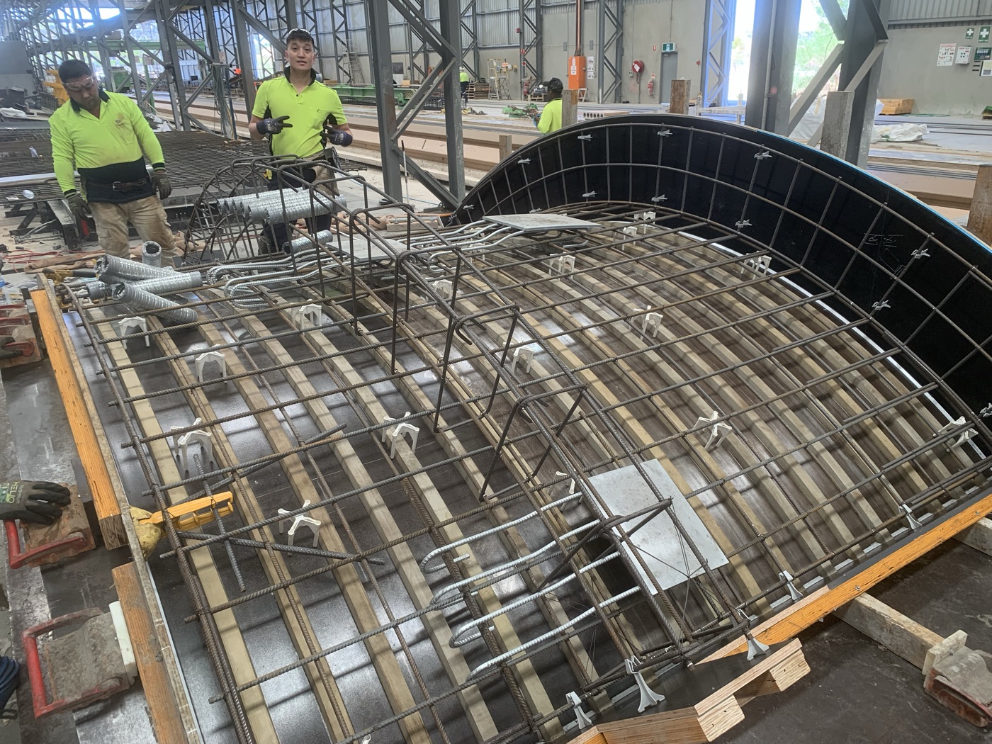 Togtuun steel fixers in full PPE fabricating a reinforcement cage for a precast concrete element